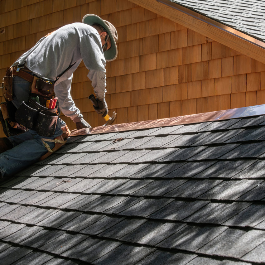 Roofer working on asphalt shingles